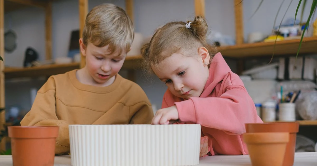 子どもと保護者が一緒にプランターへ水やりをする様子